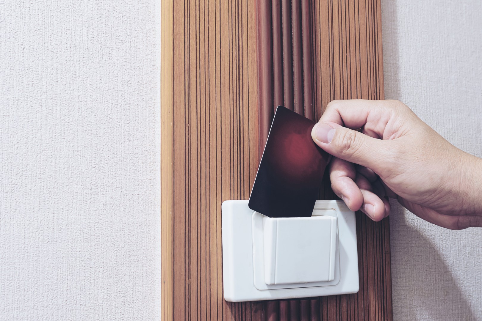 Man putting key card switch in hotel room